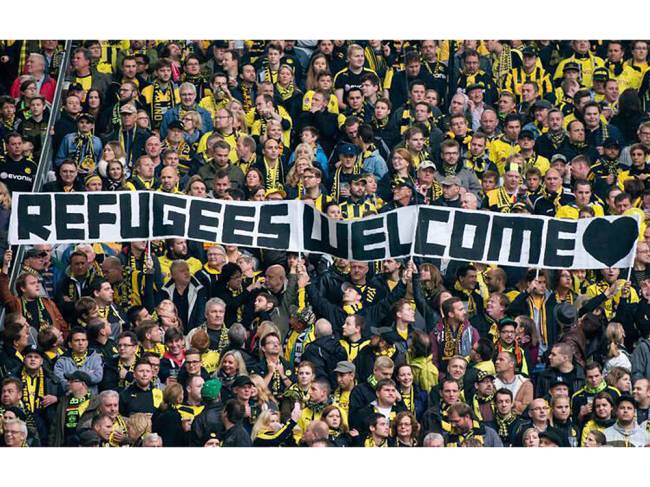 alx_cnlrkz-w8aetwzc-jpg_large_original.jpeg Torcida do Borussia Dortmund, da Alemanha, com faixa “Bem-vindos, refugiados”