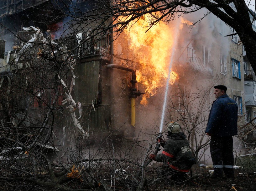 Bombeiro tenta combater incêndio em uma casa que foi bombardeada em Donetsk, leste da Ucrânia