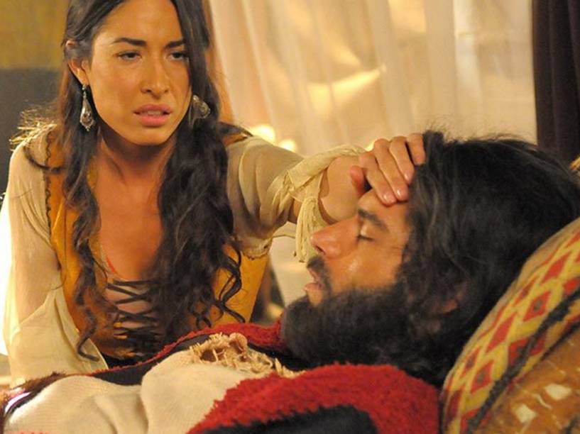 <p>Moisés (Guilherme Winter) passa mal e é socorrido pela mulher, Zípora (Giselle Itié), que acredita precisar circuncidar o filho mais novo para salvar o marido</p>