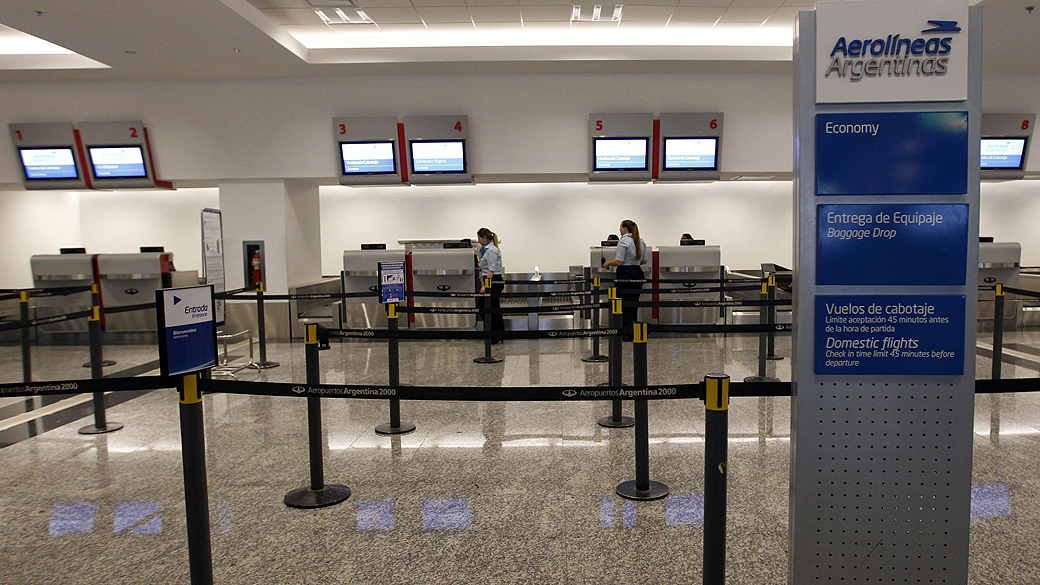 Funcionários das Aerolineas Argentinas no balcão da empresa no aeroporto de Buenos Aires durante a greve