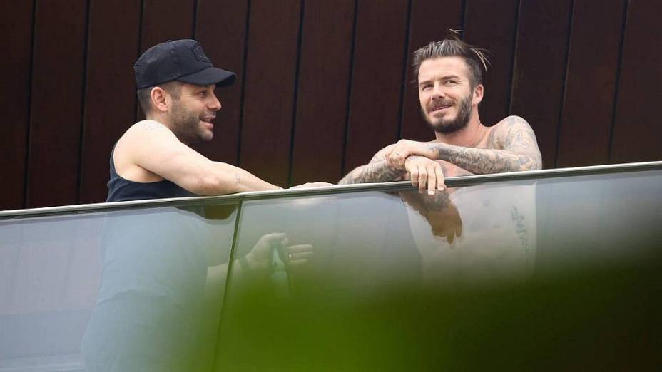 David Beckham aparece na sacada do hotel onde está hospedado, no Rio