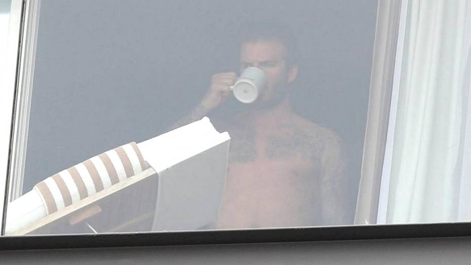 David Beckham aparece na sacada do hotel onde está hospedado, no Rio