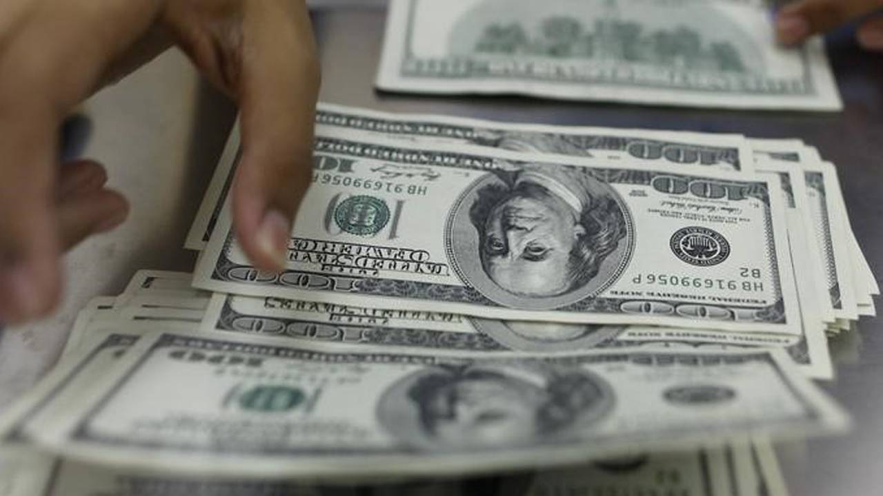 Mulher conta notas de dólar norte-americano em casa de câmbio