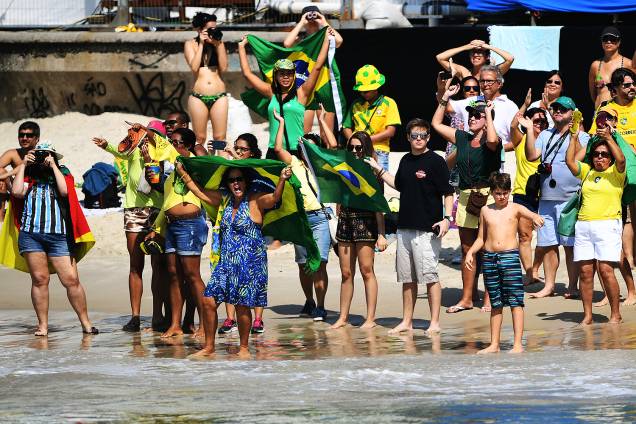 Torcedores levantam bandeiras e fotografam a prova de maratona aquática feminina, na beira da praia de Copacabana, Rio de Janeiro Torcedores levantam bandeiras e fotografam a prova de maratona aquática feminina, na beira da praia de Copacabana, Rio de Janeiro