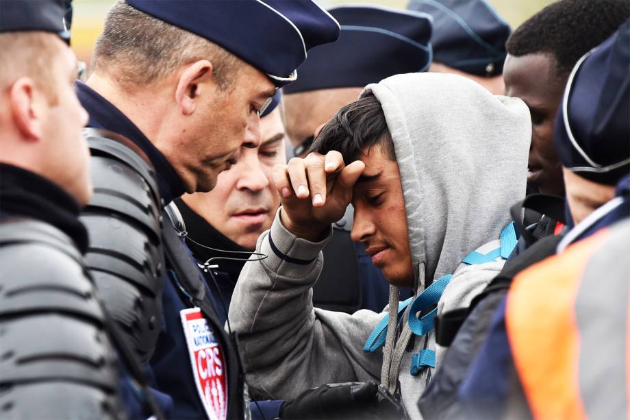 Migrante é visto próximo a policiais franceses durante a operação de evacuação do acampamento localizado em Calais - 24/10/2016