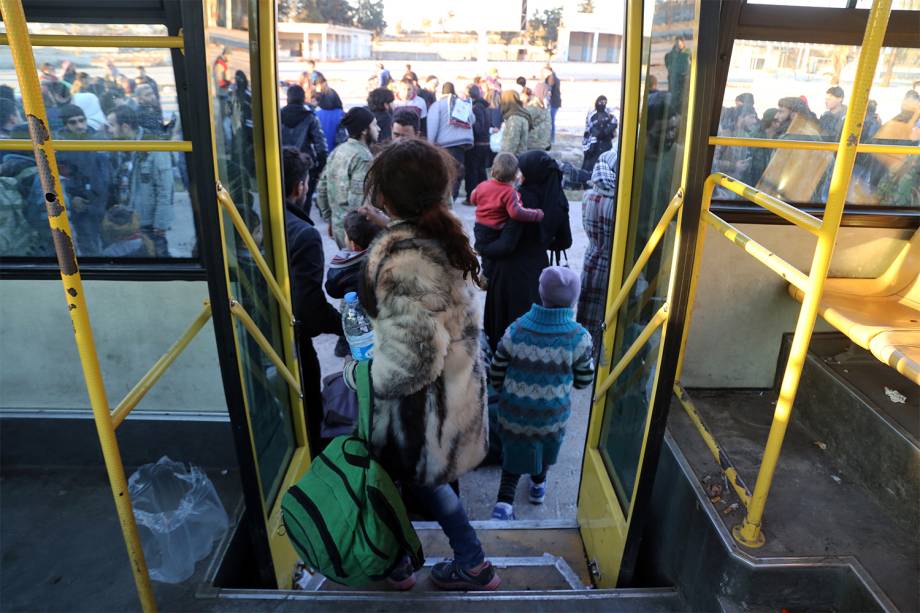 Sírios entram em ônibus para ser evacuados da região de Khan al-Aassal, oeste de Alepo - 15/12/2016