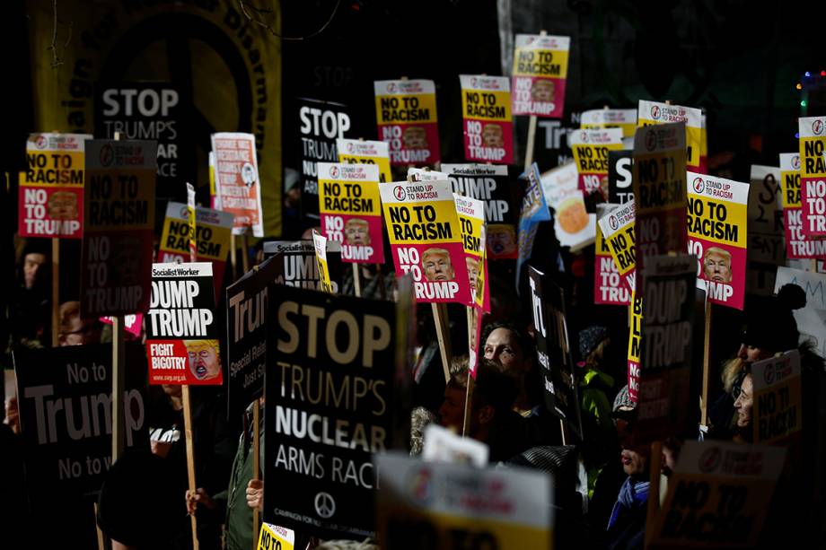 Manifestantes seguram cartazes contra o presidente eleito dos Estados Unidos, Donal Trump, durante sua posse no Capitólio