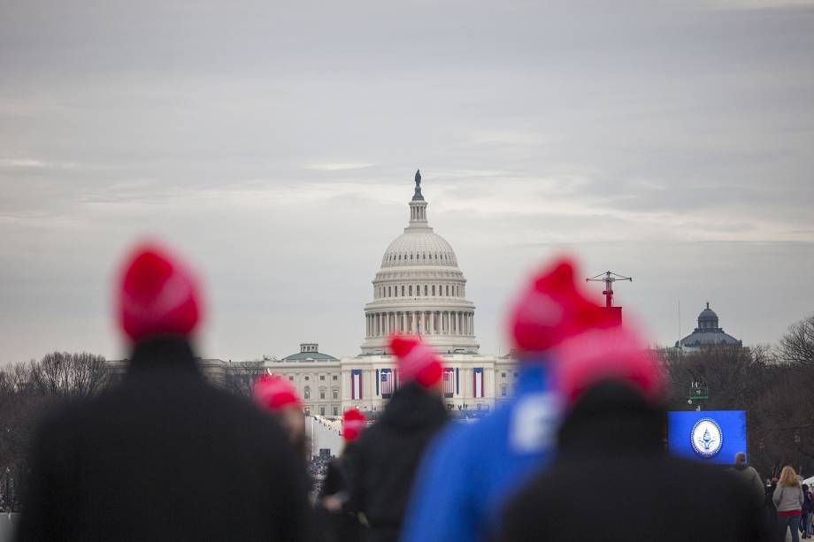 Pessoas começam a chegar para a cerimônia de posse de Donald Trump diante do Monumento de Washington enquanto parte da cidade é iluminada pelo sol no amanhecer