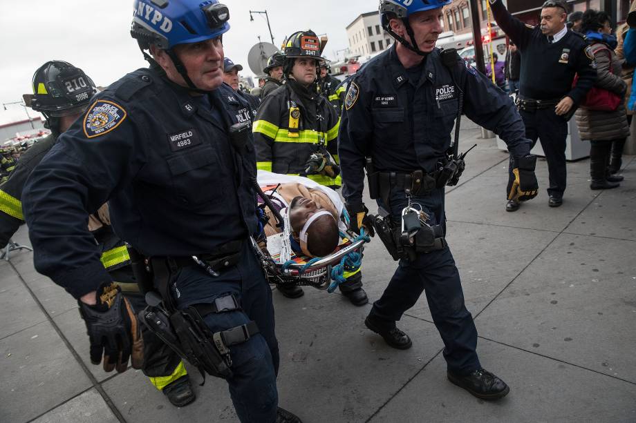 Policiais e bombeiros de Nova York socorrem os feridos após um descarrilamento na estação Atlantic, no Brooklyn - 04/01/2017