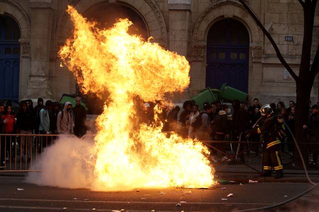 Bombeiro tenta apagar chamas iniciadas no protesto de estudantes contra a violência policial em Paris, França - 23/02/2017 Bombeiro tenta apagar chamas iniciadas no protesto de estudantes contra a violência policial em Paris, França - 23/02/2017
