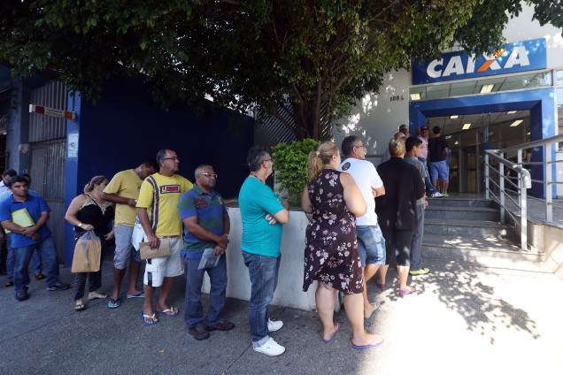 Pessoas se dirigem as agências da Caixa Econômica Federal para obter informações sobre FGTS Pessoas se dirigem as agências da Caixa Econômica Federal para obter informações sobre FGTS