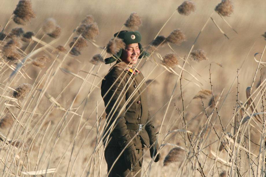 Soldado norte-coreano sorri próximo a cidade de Sinuiju, Coreia do Norte, visto do lado oposto na cidade de Dandong, China - 06/01/2016