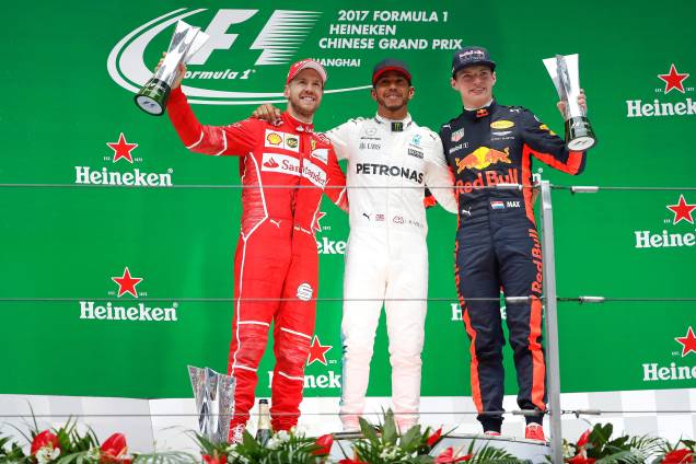 O piloto britânico da Mercedes Lewis Hamilton, festeja no pódio ao lado do alemão Sebastian Vettel da Ferrari e do holandês Max Verstappen da Red Bull - 09/04/2017 O piloto britânico da Mercedes Lewis Hamilton, festeja no pódio ao lado do alemão Sebastian Vettel da Ferrari e do holandês Max Verstappen da Red Bull - 09/04/2017