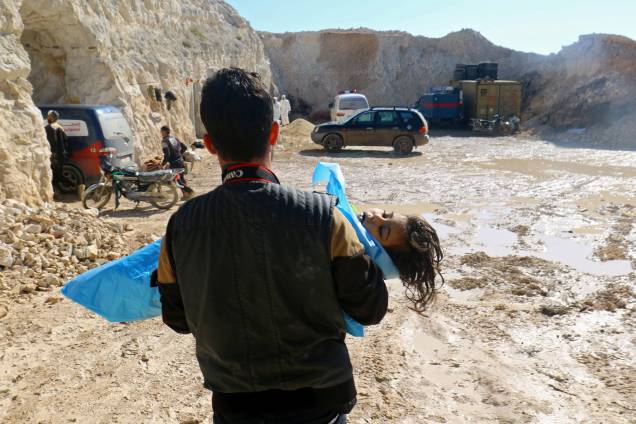 Fotógrafo carrega o corpo de uma criança morta, depois de um suposto ataque com gás na cidade de Khan Sheikhoun, na Síria - 04/04/2017 Fotógrafo carrega o corpo de uma criança morta, depois de um suposto ataque com gás na cidade de Khan Sheikhoun, na Síria - 04/04/2017