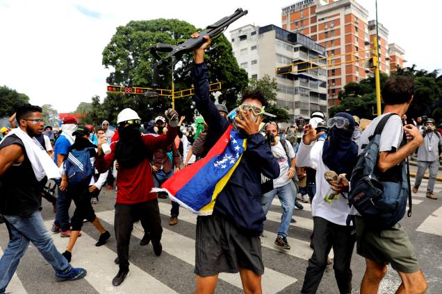 Manifestante da oposição ao Presidente Nicolás Maduro toma da polícia uma arma durante confronto no protesto em Caracas, na Venezuela - 03/05/2017 Manifestante da oposição ao Presidente Nicolás Maduro toma da polícia uma arma durante confronto no protesto em Caracas, na Venezuela - 03/05/2017