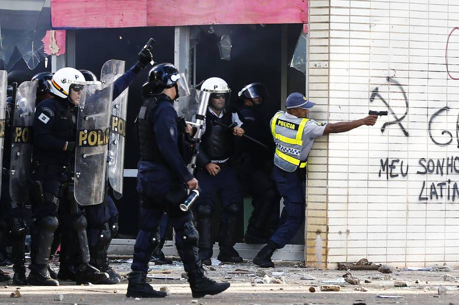 PM com arma de fogo em frente ao Ministério da Agricultura - Manifestantes de centrais sindicais e movimentos sociais realizam marcha, chamada de "Ocupa Brasília", nesta quarta-feira (24), na capital federal.