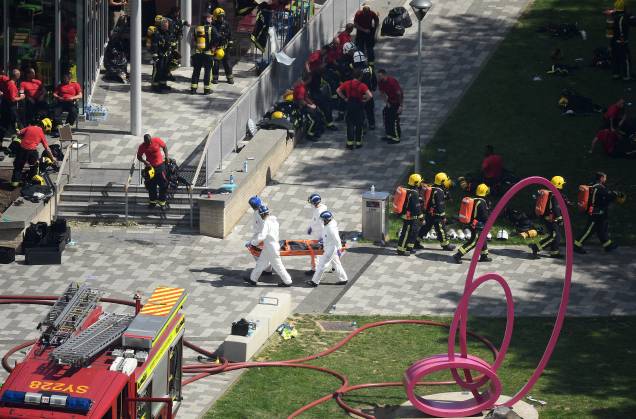 Equipe de emergencia do corpo de bombeiros, policiais e demais ajudantes ao lado do local do incêndio no Grenfell Tower, em Londres - 14/06/2017 Equipe de emergencia do corpo de bombeiros, policiais e demais ajudantes ao lado do local do incêndio no Grenfell Tower, em Londres - 14/06/2017