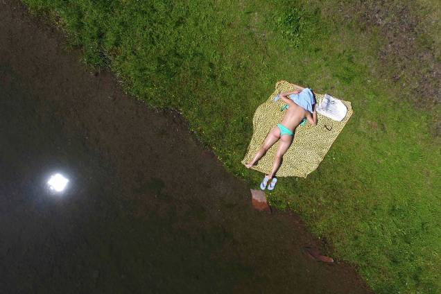Mulher toma o sol às margens do rio Yenisei em um dia quente de verão em Krasnoyarsk, na Rússia - 22/06/2017 Mulher toma o sol às margens do rio Yenisei em um dia quente de verão em Krasnoyarsk, na Rússia - 22/06/2017