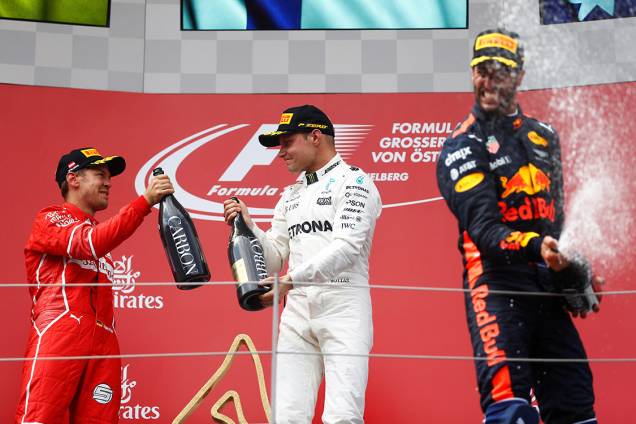 O finlandês Valtteri Bottas, da Mercedes, comemora no pódio com Sebastian Vettel, da Ferrari, e Daniel Ricciardo, da Red Bull Racing, após vencer o GP da Áustria O finlandês Valtteri Bottas, da Mercedes, comemora no pódio com Sebastian Vettel, da Ferrari, e Daniel Ricciardo, da Red Bull Racing, após vencer o GP da Áustria