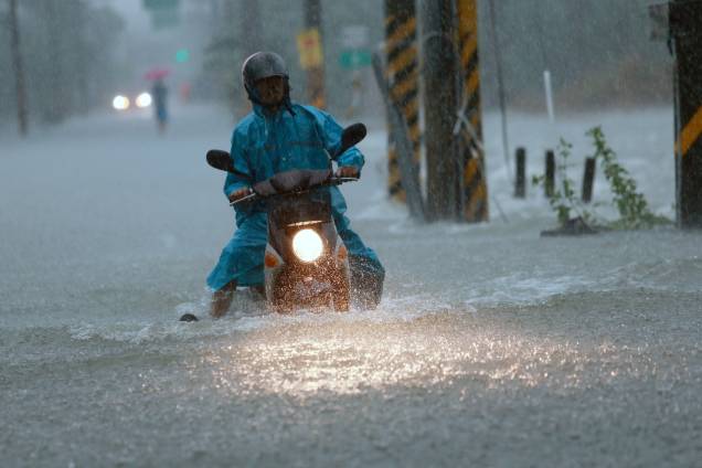 Motociclista atravessa uma rua inundada após a passagem do tufão Nesat em Pingtung, no sul de Taiwan - 29/07/2017 Motociclista atravessa uma rua inundada após a passagem do tufão Nesat em Pingtung, no sul de Taiwan - 29/07/2017