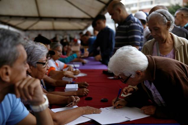 Mulher assina documento de plebiscito que vota contra o presidente Nicolas Maduro em Caracas, na Venezuela - 16/07/2017 Mulher assina documento de plebiscito que vota contra o presidente Nicolas Maduro em Caracas, na Venezuela - 16/07/2017