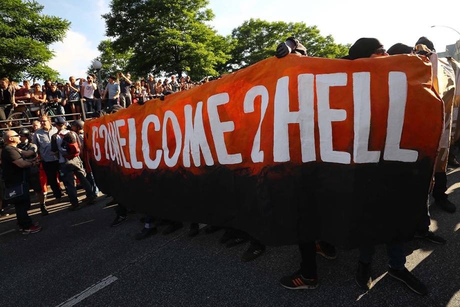 Manifestantes levantam cartazes para protestar contra a conferência do G20, em que líderes das maiores economias do mundo se reúnem para discutir assuntos como economia, política, meio ambiente, acordos de paz etc. - 06/07/2017