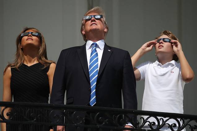 Presidente Donald Trump e sua esposa, Melania Trump, e o filho do casal, Barron Trump, observam o eclipse solar total no balcão da Casa Branca, em Washington Presidente Donald Trump e sua esposa, Melania Trump, e o filho do casal, Barron Trump, observam o eclipse solar total no balcão da Casa Branca, em Washington