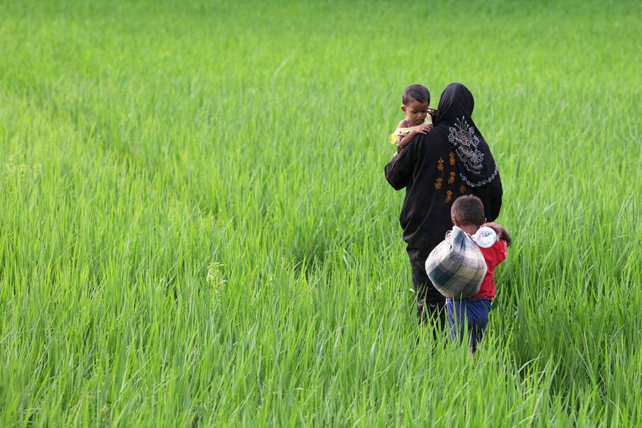 Mulher rohingya caminha com seus filhos por um campo em Bangladesh, após fugir de Myanmar - 10/09/2017