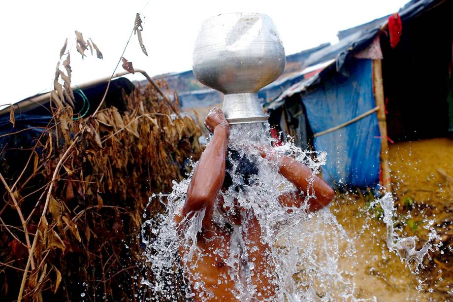 Homem rohingya toma banho ao lado de fora de seu abrigo, em um campo de refugiados em Bangladesh - 13/09/2017