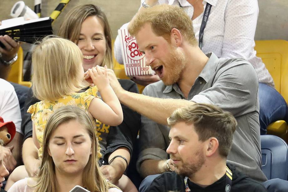 Hayley Henson e a filha Emily Henson sentam-se com o Príncipe Harry para comer pipoca e assistir às finais do vôlei durante os Jogos Invictus 2017 no Centro de Atletismo Mattamy, em Toronto, no Canadá