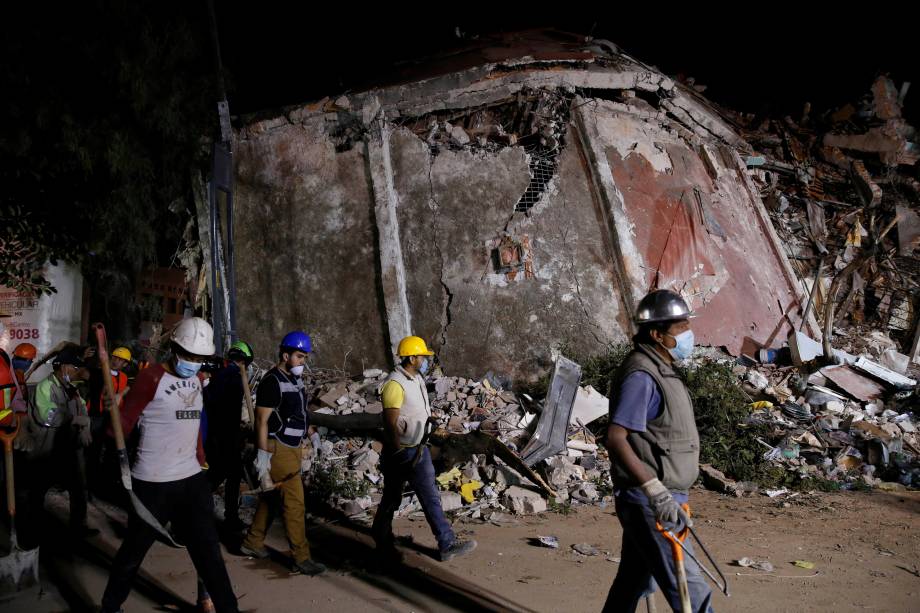 Trabalhadores passam em frente a um prédio abalado pelo terremoto de 7,1 graus de magnitude que atingiu o México - 20/09/2017