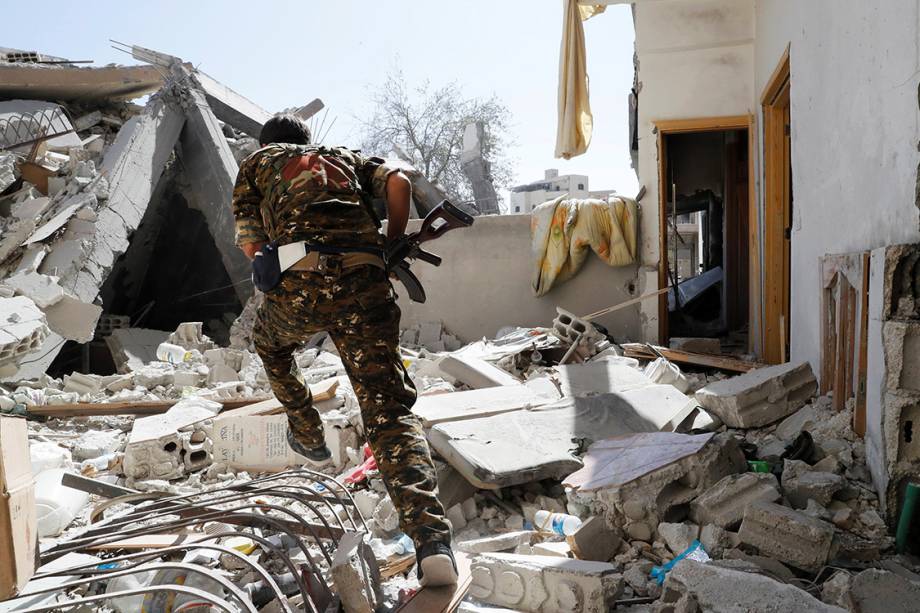 Soldado das Forças Democráticas Sírias corre para se proteger durante batalha contra militantes do Estado Islâmico, em Raqqa - 04/10/2017