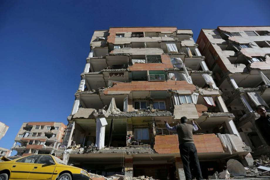 Homem reage ao olhar para um edifício danificado após um terremoto no condado de Sarpol-e Zahab, em Kermanshah, no Irã - 13/11/2017
