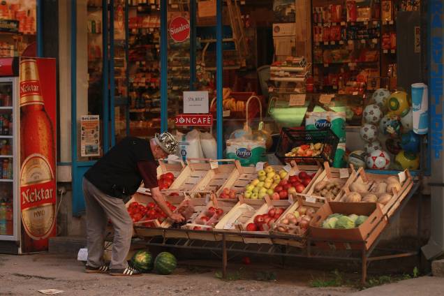 Um homem organiza os alimentos na vitrine de uma mercearia na região da República Srpska, no leste da Bósnia. Um homem organiza os alimentos na vitrine de uma mercearia na região da República Srpska, no leste da Bósnia.