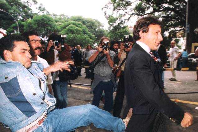 Hercules Adams do Nascimento, manifestante antiprivatização, ao lado do sindicalista Júlio César dos Santos, chutando o investidor Aristides Maria Ricci do Nascimento, dono da Novatrading, após leilão de privatização da Usiminas, na Bolsa de Valores do Rio de Janeiro - 24/09/1991 Hercules Adams do Nascimento, manifestante antiprivatização, ao lado do sindicalista Júlio César dos Santos, chutando o investidor Aristides Maria Ricci do Nascimento, dono da Novatrading, após leilão de privatização da Usiminas, na Bolsa de Valores do Rio de Janeiro - 24/09/1991