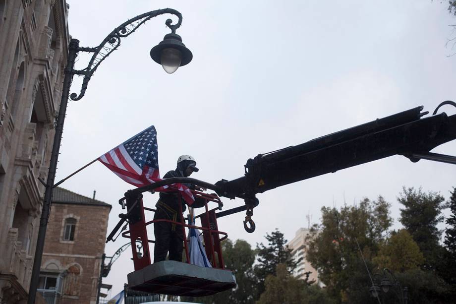Funcionário estende uma bandeira americana próximo ao consulado dos Estados Unidos, em Jerusalém - 06/12/2017 Funcionário estende uma bandeira americana próximo ao consulado dos Estados Unidos, em Jerusalém - 06/12/2017