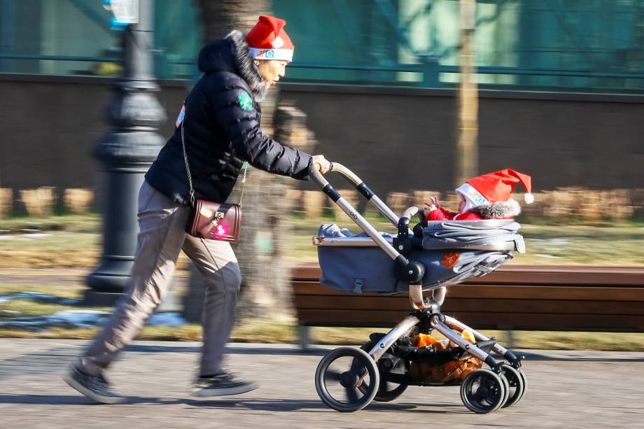 Mulher e criança usam gorro natalino durante desfile de Natal na cidade de Almaty, localizada no Cazaquistão - 24/12/2017