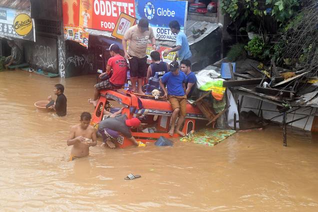 Moradores se equilibram em cima de um caminhão parcialmente coberto por água depois de tempestade atingir a cidade de Cagayan de Oro, nas Filipinas - 23/12/2017 Moradores se equilibram em cima de um caminhão parcialmente coberto por água depois de tempestade atingir a cidade de Cagayan de Oro, nas Filipinas - 23/12/2017