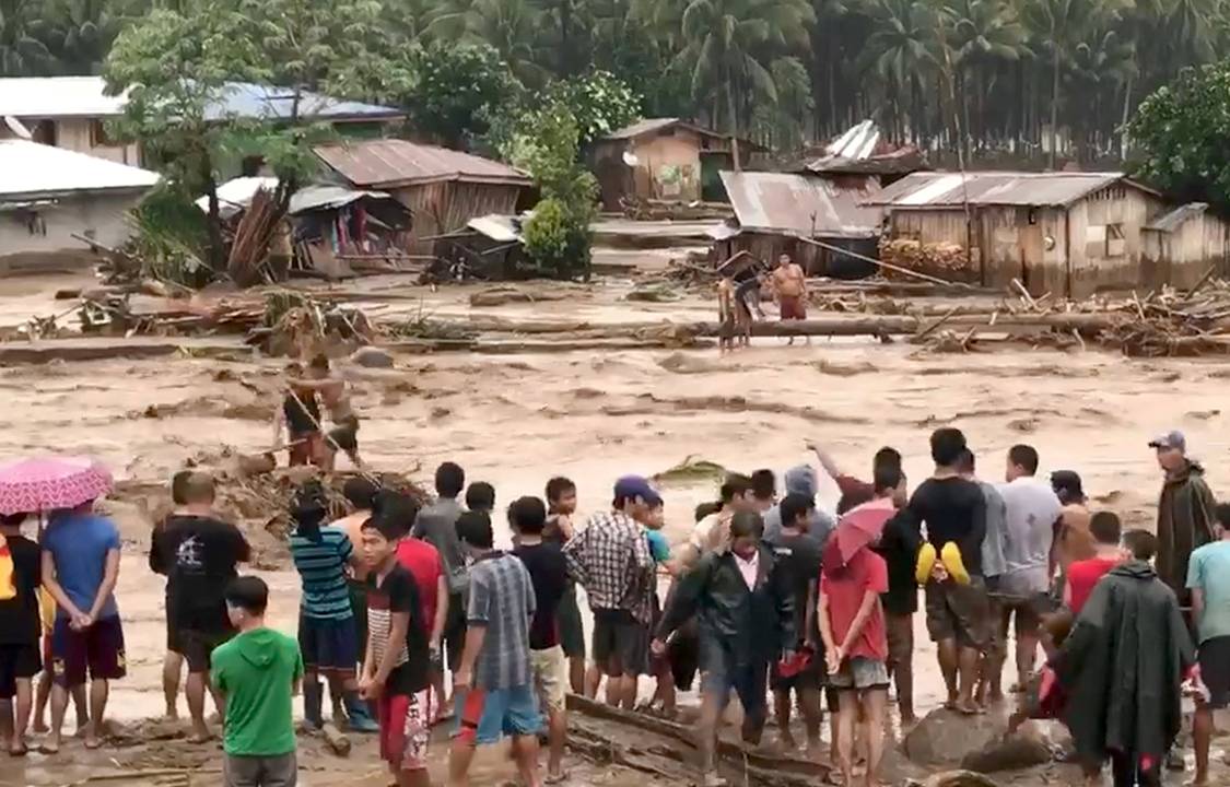 Pessoas ajudam no resgate de vítimas de tempestade que atingiu a região de Lanao del Norte, nas Filipinas