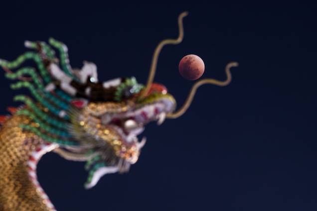 Superlua azul de sangue nasce atrás de uma estátua de dragão de um templo budista de Bangkok, Tailândia Superlua azul de sangue nasce atrás de uma estátua de dragão de um templo budista de Bangkok, Tailândia