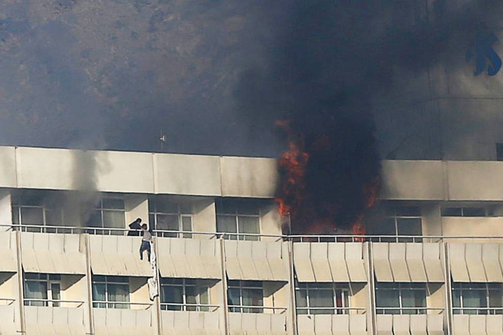 Homem se pendura na sacada do Hotel Intercontinental, localizado em Cabul, no Afeganistão, após ataque - 21/01/2018