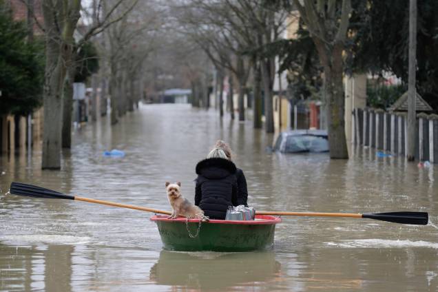Moradora usa um barco a remo para atravessar com seu cão uma rua inundada no bairro de Villeneuve-Saint-Georges, em Paris - 24/01/2018 Moradora usa um barco a remo para atravessar com seu cão uma rua inundada no bairro de Villeneuve-Saint-Georges, em Paris - 24/01/2018