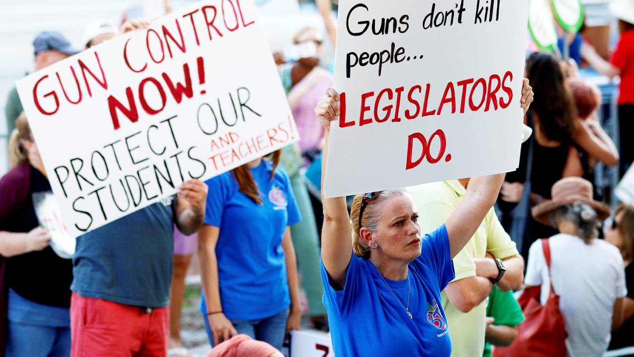 Manifestantes erguem placas e cartazes durante protesto pela reforma na lei do controle de venda de armas, em Fort Lauderdale, no estado americano da Flórida - 17/02/2018