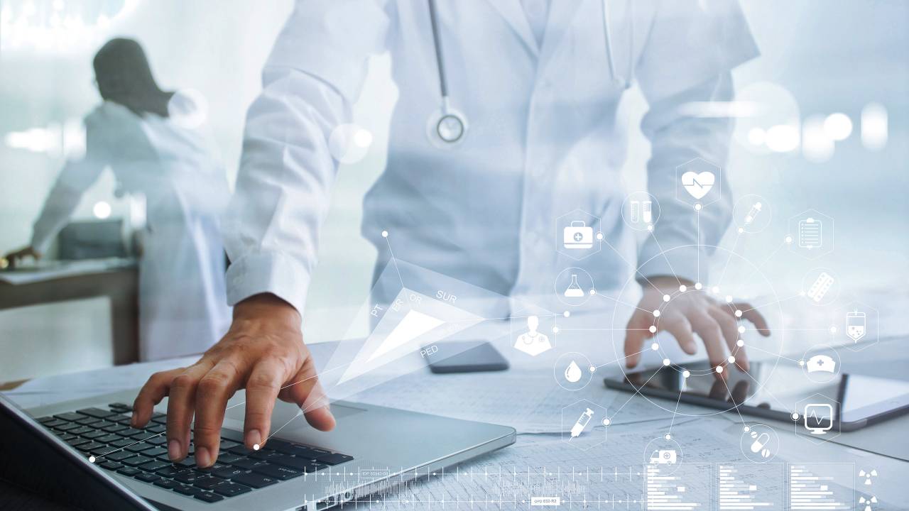 Médico usa o computador para acessar informações sobre a área da saúde