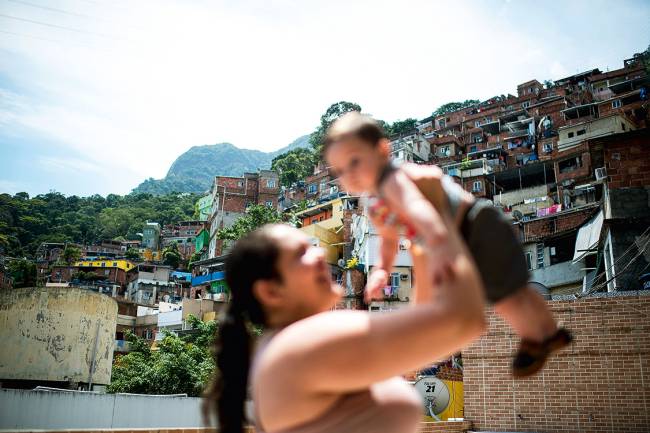 Aprendendo a sobreviver – Camila não larga o filho Davi, de 7 meses, que ainda chora muito cada vez que ouve o fogo cruzado