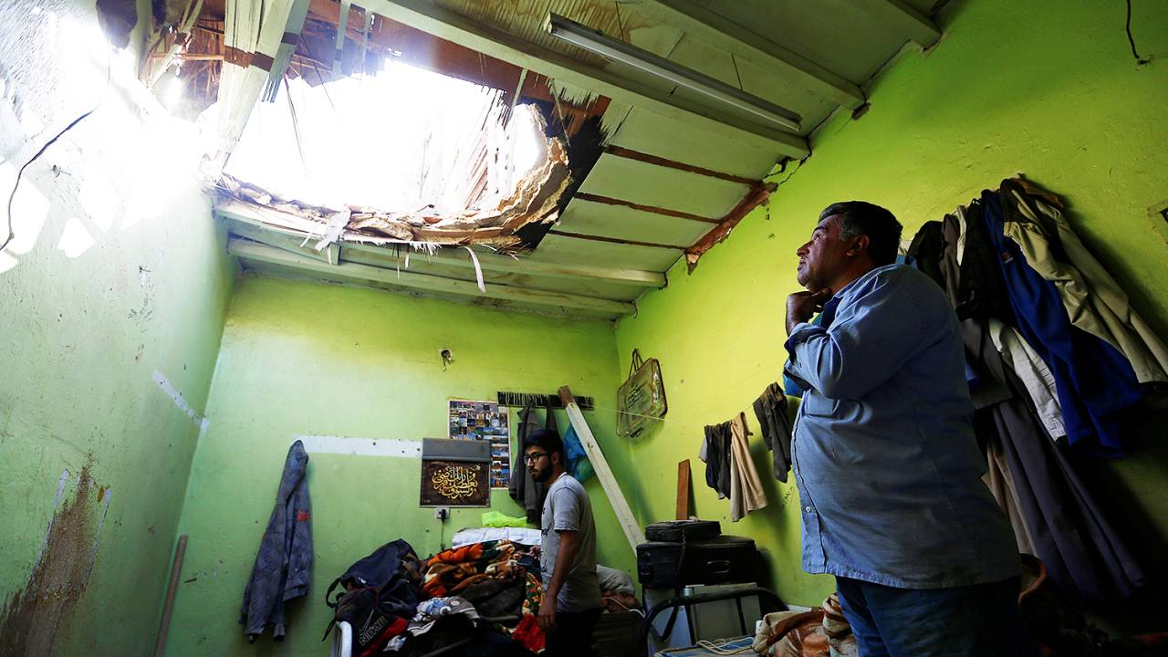 Homem observa buraco feito por míssil balístico em telhado de sua casa em Riade, na Arábia Saudita - 26/03/2018