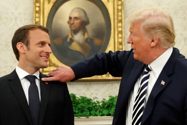 O presidente dos Estados Unidos, Donald Trump, limpa o paletó do presidente francês Emmanuel Macron após coletiva de imprensa na Casa Branca, em Washington - 24/04/2018 O presidente dos Estados Unidos, Donald Trump, limpa o paletó do presidente francês Emmanuel Macron após coletiva de imprensa na Casa Branca, em Washington - 24/04/2018