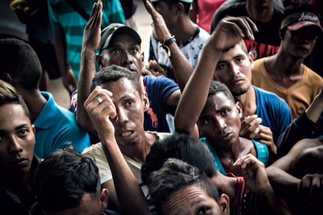 Fome e desalento - Homens se amontoam para receber refeição distribuída por voluntários em Boa Vista Fome e desalento - Homens se amontoam para receber refeição distribuída por voluntários em Boa Vista