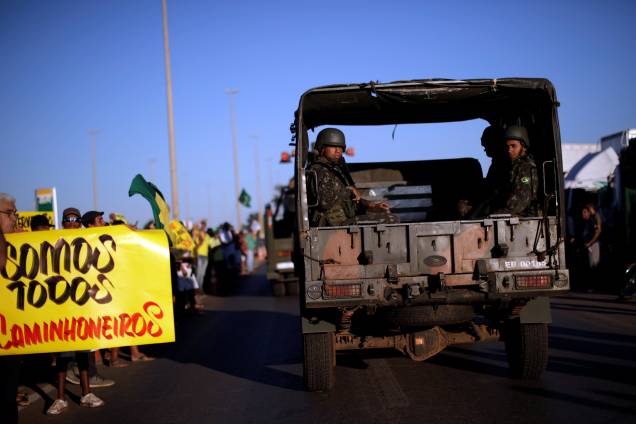 Caminhão que transporta oficiais do exército passa por manifestantes que apóiam os caminhoneiros em protesto contra os altos preços do diesel em Luziania (GO) - 27/05/2018 Caminhão que transporta oficiais do exército passa por manifestantes que apóiam os caminhoneiros em protesto contra os altos preços do diesel em Luziania (GO) - 27/05/2018