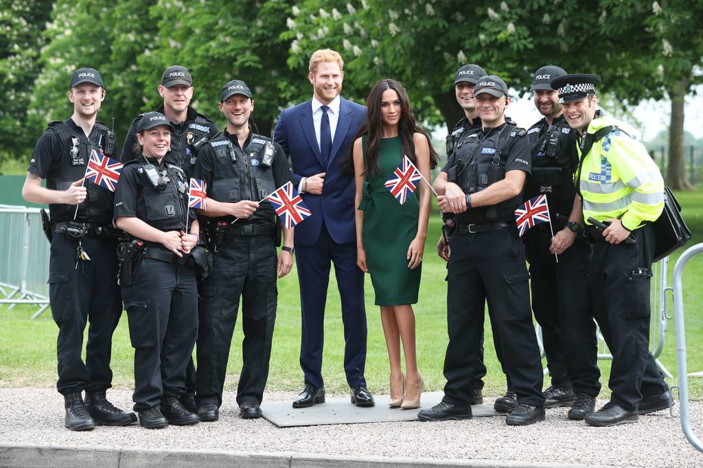 Estátuas de Harry e Meghan Markle são levadas para Windsor Policiais posam para fotos com as estátuas de cera do príncipe Harry e da atriz Meghan Markle, nos arredores do Castelo de Windsor - 16/05/2018